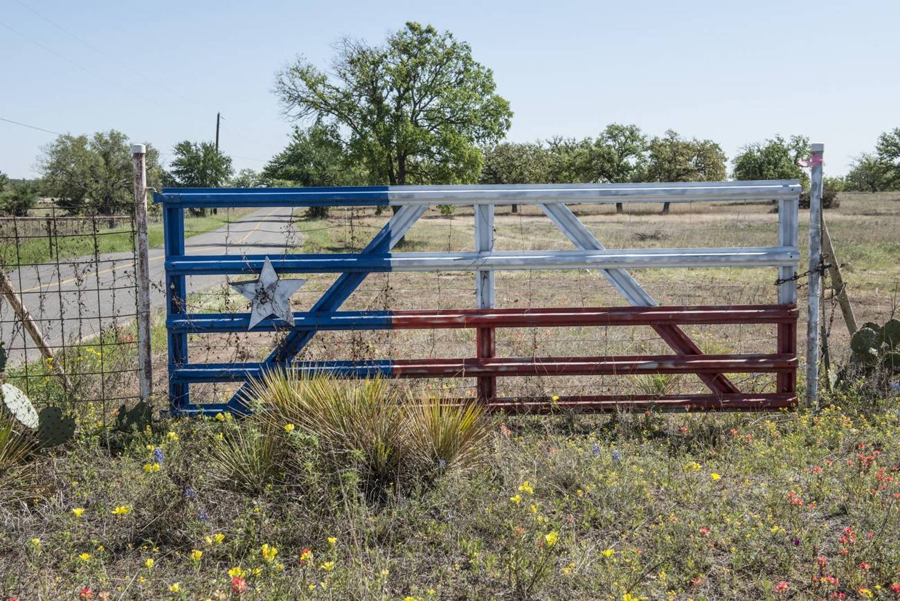 Lone star farm gate closing off a pasture in Llano County, Texas
