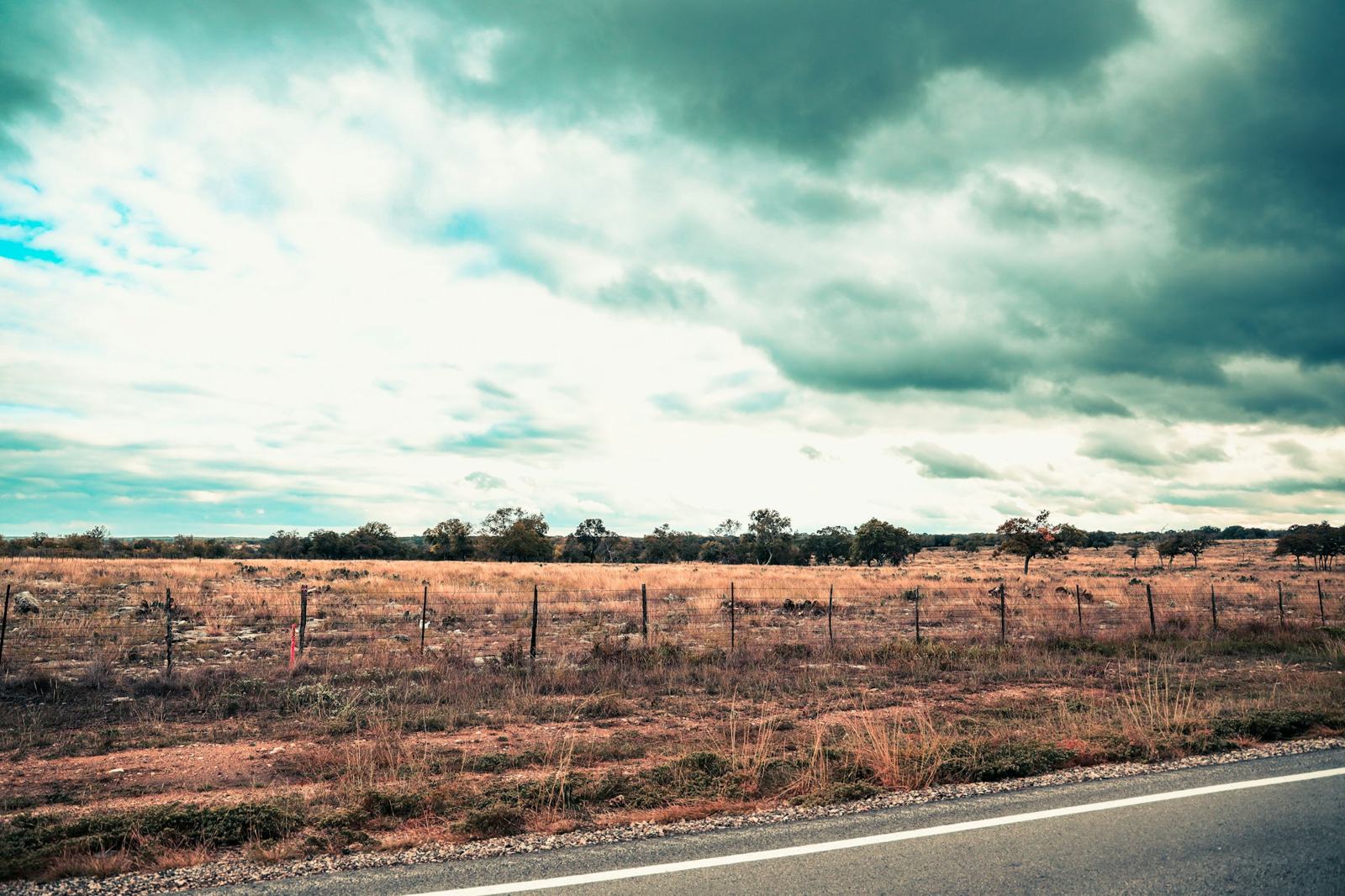 Country road beside a fenced pasture near Marble Falls, Texas